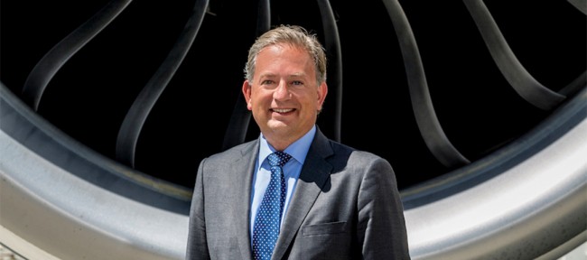 CEO in front of aircraft engine